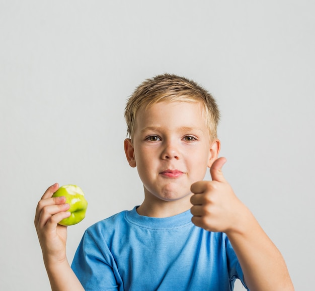 Jovem rapaz dianteiro com uma maçã verde
