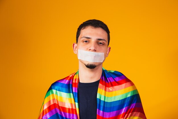 Jovem rapaz homossexual com a boca fechada em silêncio pela violência sofrida na sociedade. preconceito gay e violência