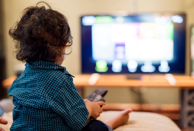 Foto grátis jovem rapaz indiano assistindo televisão