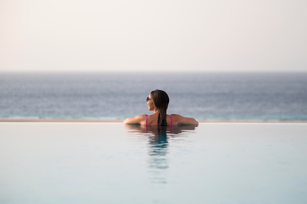 Foto grátis jovem relaxando sozinha na piscina