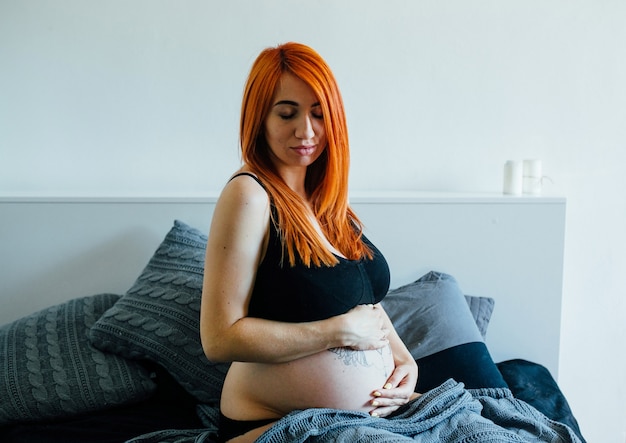 Jovem ruiva posando na cama