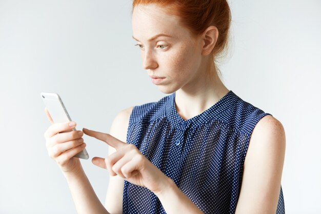 Jovem ruiva segurando um smartphone