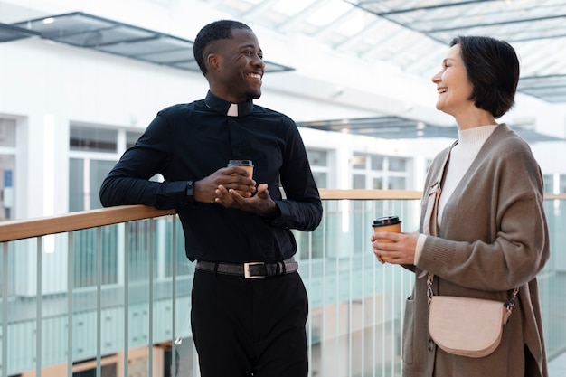 Jovem sacerdote masculino conhecendo uma mulher para direção espiritual