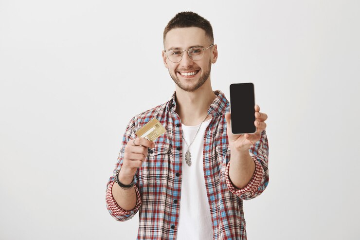Foto grátis jovem satisfeito de óculos, posando com seu telefone e cartão