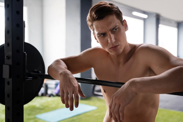 Foto grátis jovem se exercitando na academia de musculação