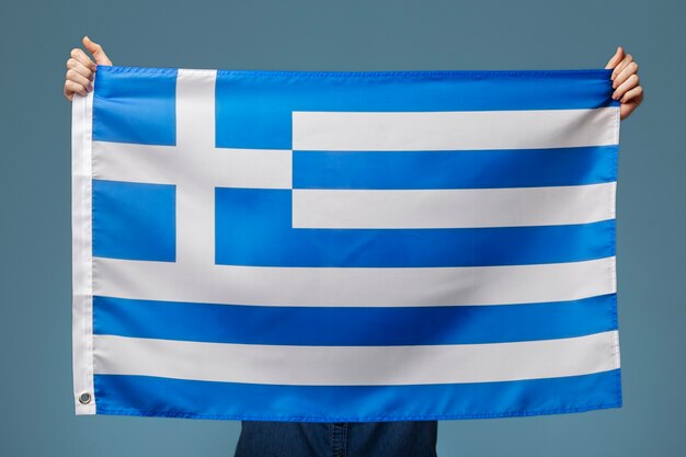 Jovem segurando a bandeira da Grécia