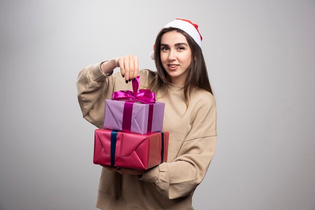 Jovem segurando dois presentes de Natal