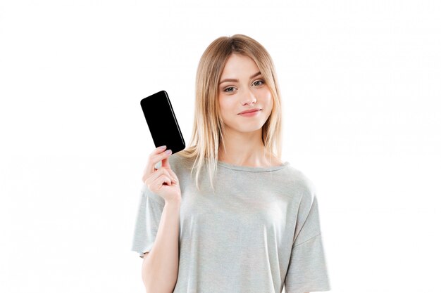 Jovem, segurando o telefone móvel em branco scren e olhando para a câmera