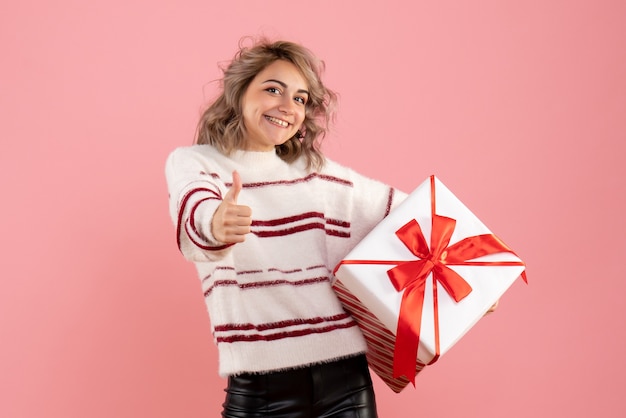 Jovem segurando um presente de natal rosa