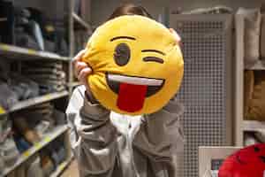 Foto grátis jovem segurando um travesseiro sorridente nas mãos em uma loja