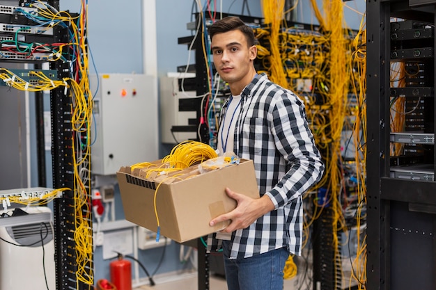 Jovem, segurando uma caixa com fios tiro médio