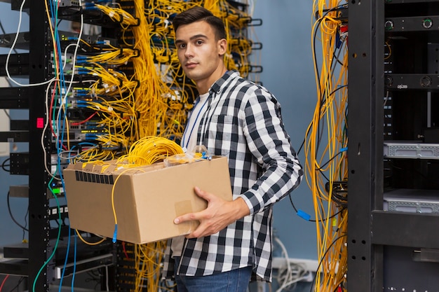 Foto grátis jovem, segurando uma caixa com fios