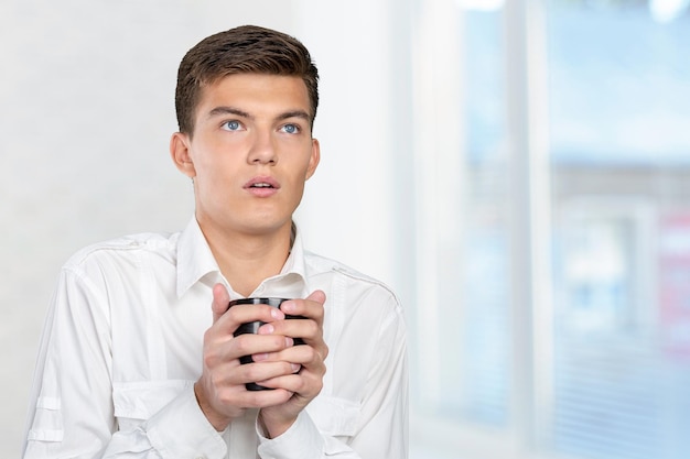 Jovem segurando uma xícara quente de chá café