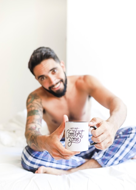 Jovem sem camisa, segurando a xícara de café