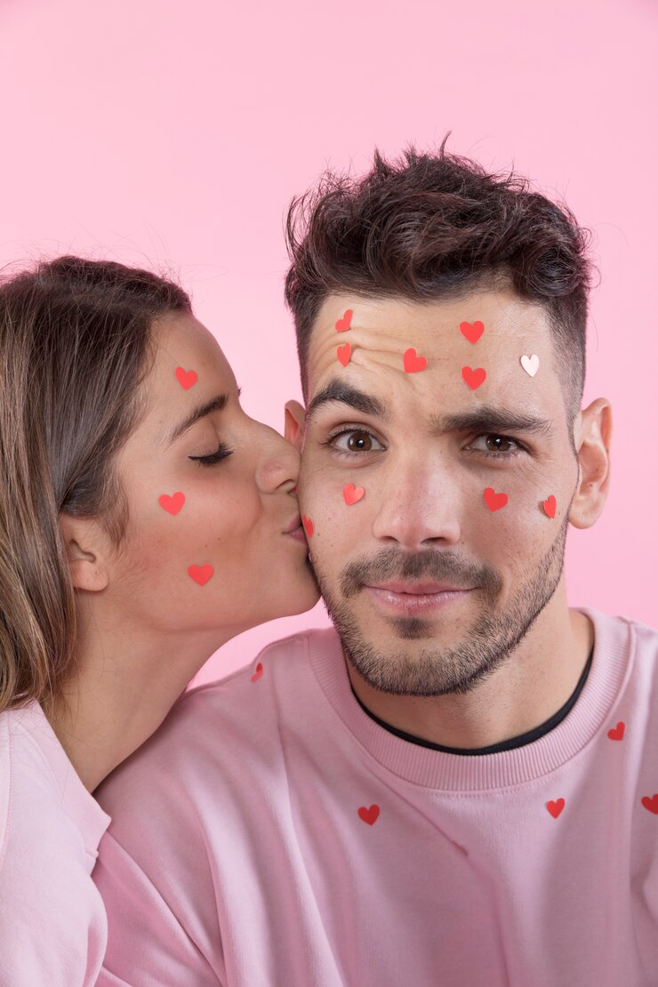 Foto grátis jovem senhora beijando cara com corações de papel em rostos