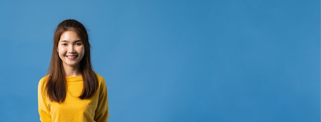 Foto grátis jovem senhora da ásia com um sorriso largo, vestida com roupas casuais e olhando para a câmera sobre fundo azul. mulher feliz adorável feliz alegra sucesso. fundo de banner panorâmico com espaço de cópia.