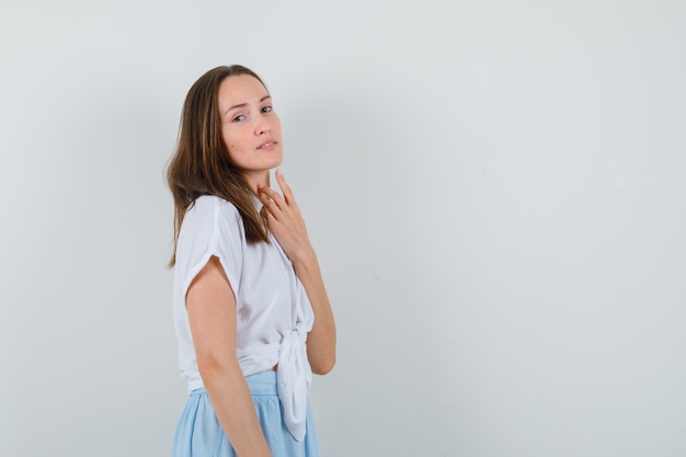 Jovem senhora de blusa e saia olhando para o lado enquanto posava e parecendo atraente, espaço livre para seu texto