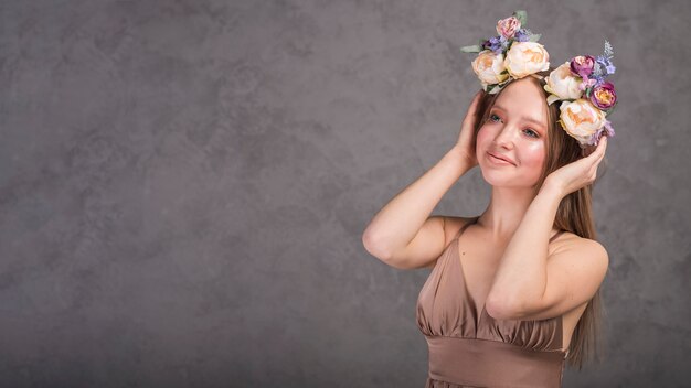 Jovem senhora romântica sorridente vestido com coroa de flores linda