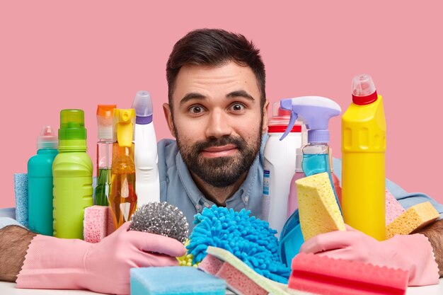 Jovem sentado ao lado de produtos de limpeza