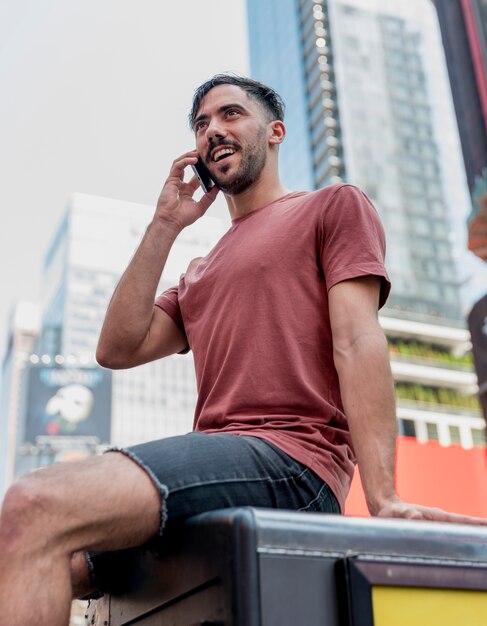 Jovem sentado e falando por telefone