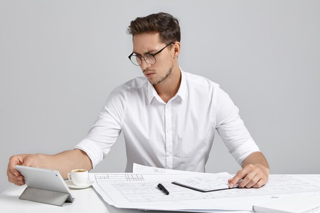 Jovem sentado na mesa e cuidando da papelada