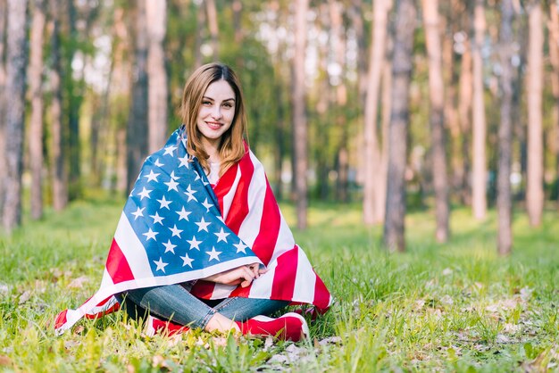 Jovem, sentando, ligado, mulher terra, embrulhando, em, bandeira americana