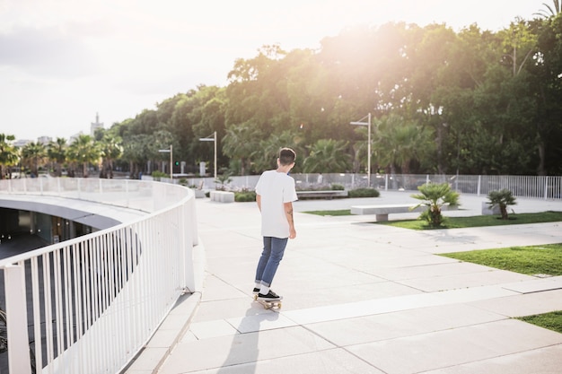 Jovem skatista a bordo de equitação no parque