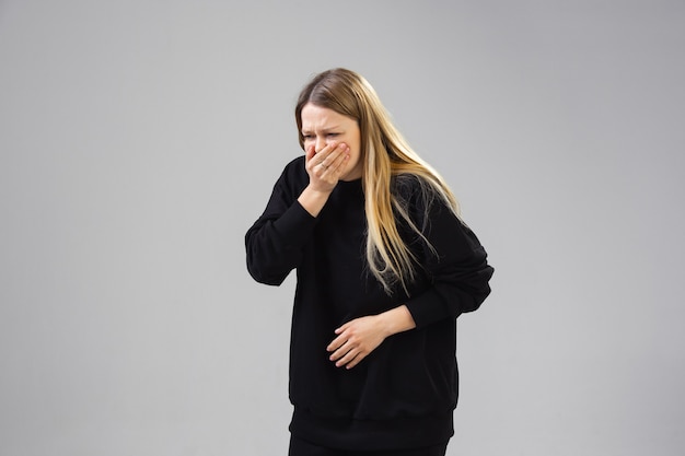 Foto grátis jovem sofre de dor, sente-se doente, doente e fraqueza isolada