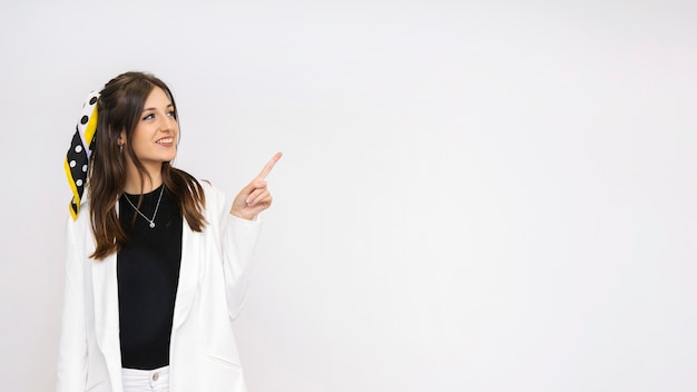 Foto grátis jovem sorridente atraente contra o pano de fundo branco, apontando para algo