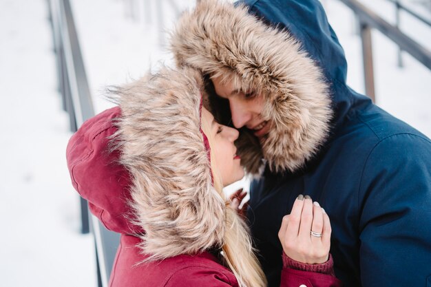 Jovem sorridente casal europeu feliz abraçando no inverno