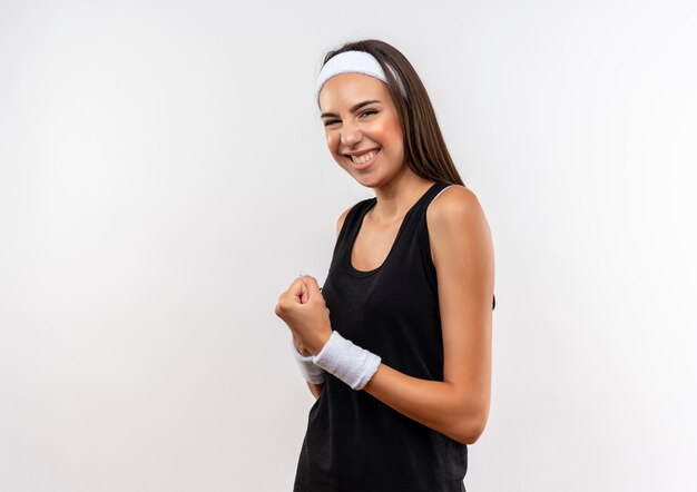 Jovem sorridente e muito esportiva usando bandana e pulseira cerrando o punho no espaço em branco