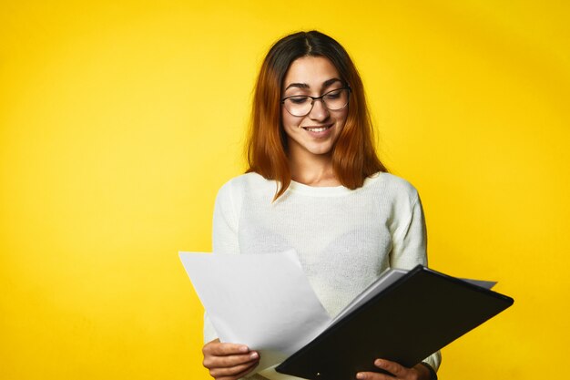 Jovem sorridente está olhando nos documentos