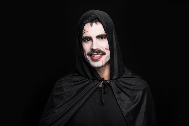 Jovem sorridente posando em traje de Halloween preto