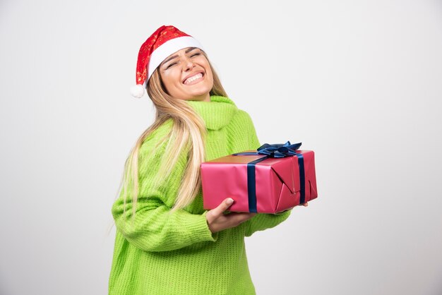 Jovem sorridente segurando um presente de Natal festivo