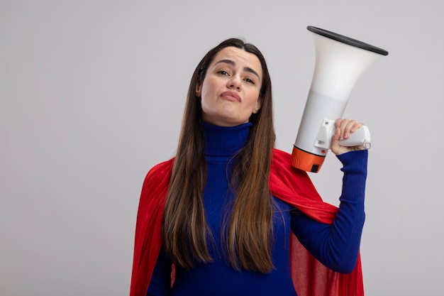 Foto grátis jovem super-heroína confiante segurando um alto-falante isolado no branco