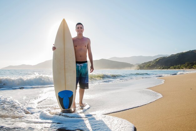 Jovem surfista na praia