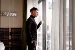 Foto grátis jovem tomando café em um quarto de hotel
