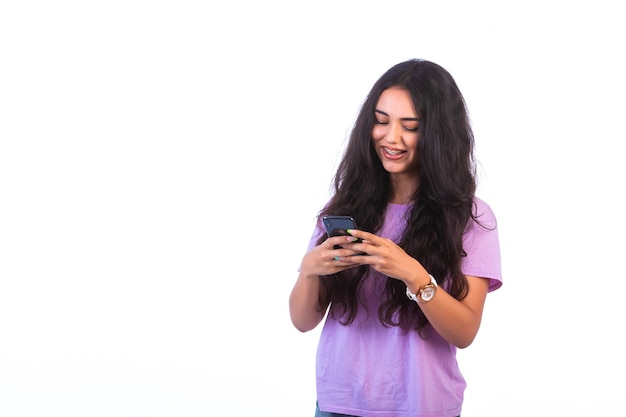 Foto grátis jovem tomando selfie ou fazendo uma vídeo chamada em fundo branco e parece positiva.