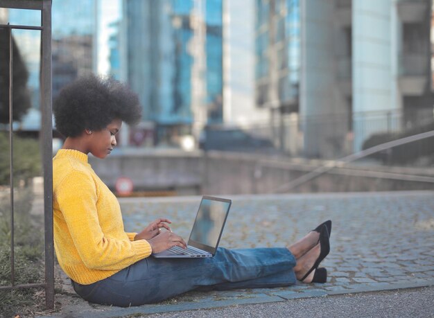 jovem trabalha com um computador na cidade