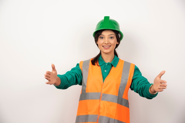 Jovem trabalhador da construção civil feminino em fundo branco.