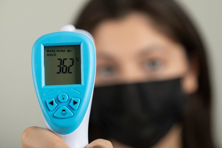 Foto grátis jovem trabalhador médico, verificando a temperatura.