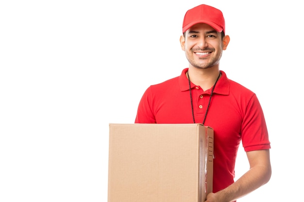 Jovem trabalhador sorrindo enquanto carregava encomendas sobre fundo branco