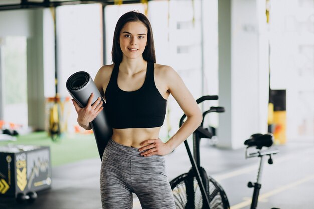 Jovem treinadora se exercitando na academia