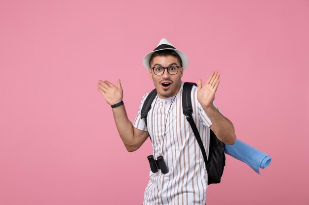 Jovem turista masculino em uma camiseta branca no fundo rosa