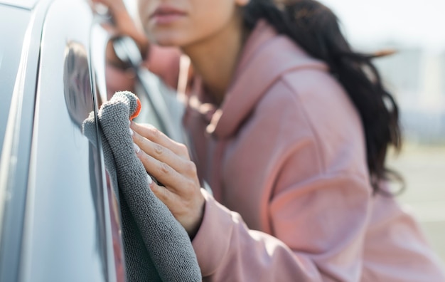 Foto grátis jovem turva, limpando o carro