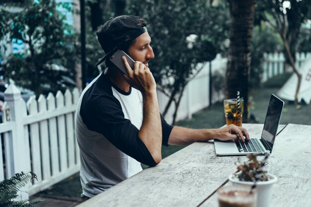 Jovem usa um smartphone em um café, navega na internet, assiste a vídeos, bebe