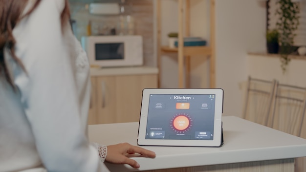 Foto grátis jovem usando aplicativo de casa inteligente com comando de voz para acender a luz por tablet