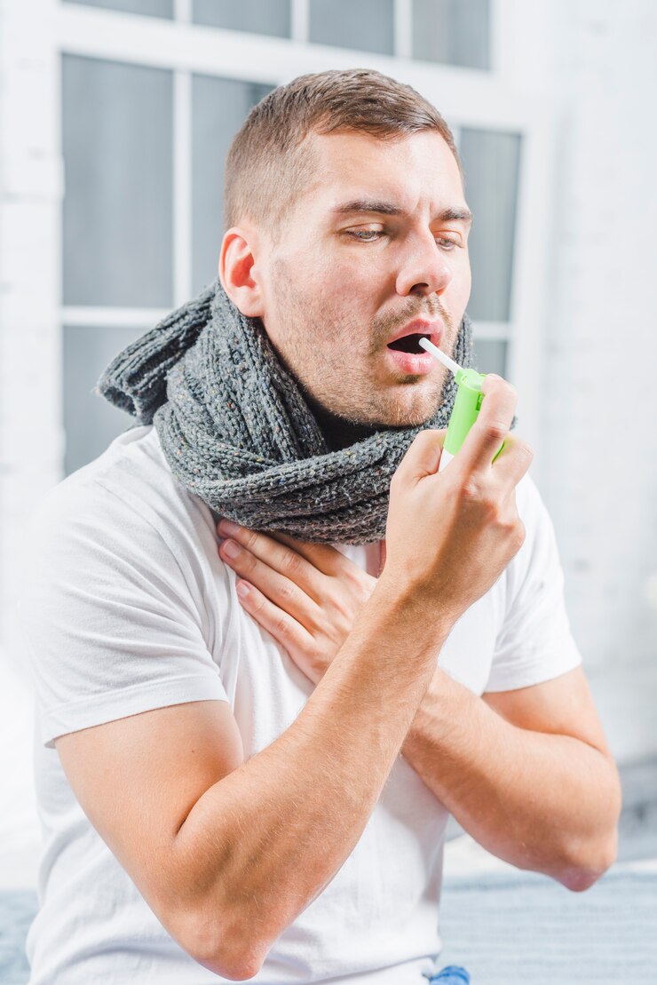 Foto grátis jovem usando um spray analgésico para suavizar a garganta