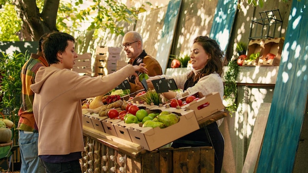 Jovem vendedor dando amostras de maçãs grátis aos clientes