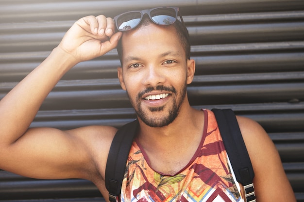 Jovem vestindo blusa colorida e óculos escuros